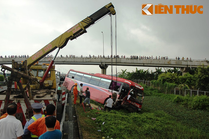 Chiếc xe khách sau khi tông vào xe tải đã lao qua dải phân cách xuống ruộng đang được lực lượng cứu hộ đưa ra khỏi hiện trường.