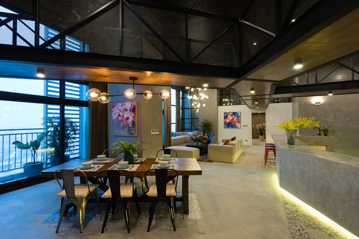 Căn hộ thông tầng độc đáo được kết hợp 2 tầng với diện tích 350 m2. Phòng khách rộng lớn với đồ nội thất bằng gỗ kết hợp đá, tạo cảm giác ấm cúng. Hướng nhìn của căn hộ ra thành phố. Thiết kế khá mở và đầy sáng tạo, tối ưu hóa không gian, căn hộ là địa điểm lý tưởng để tổ chức tiệc tùng. Do vậy, nó được gọi với cái tên "căn hộ tiệc tùng". Ảnh: Archdaily.