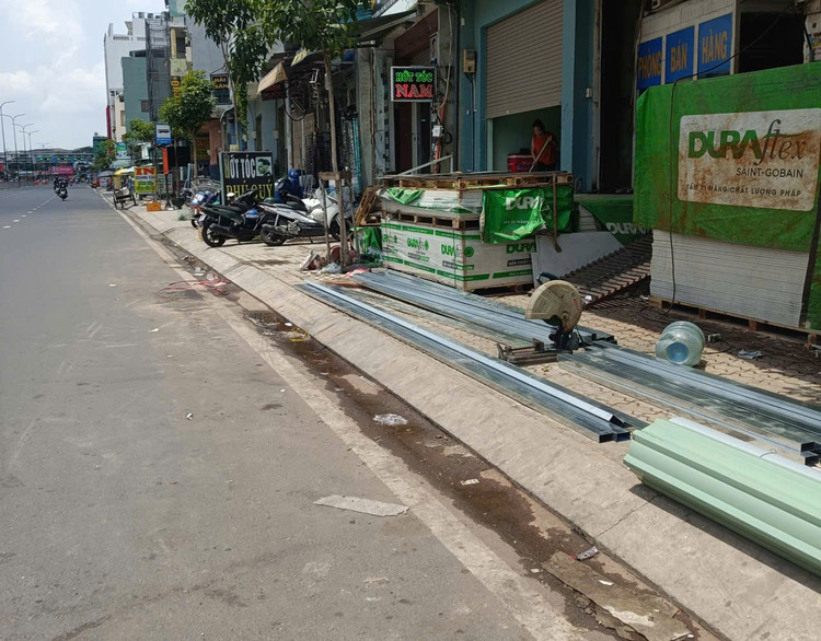 Bên cạnh việc làm chỗ để xe, bày bảng hiệu, tủ hàng, bàn ghế, vỉa hè còn là nơi để ngổn ngang vật liệu xây dựng của các cơ sở kinh doanh vlxd-01.jpg
