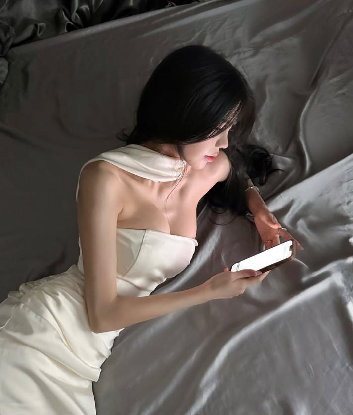 Ánh sáng dịu nhẹ, kết hợp với cách tạo dáng tinh tế, đã làm nổi bật những đường cong mềm mại và vẻ đẹp gợi cảm của Mai Dora.