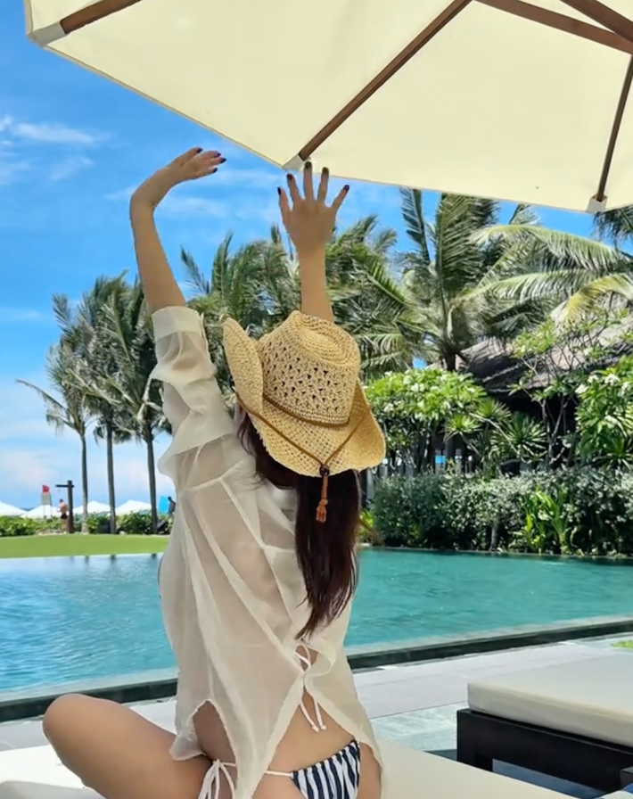 Ở bức hình bikini chụp từ phía sau, nàng hot girl Thanh Hóa mặc áo choàng mỏng xuyên thấu, để lộ bụng dưới đang “lấp ló” nhô cao càng củng cố tin vui.