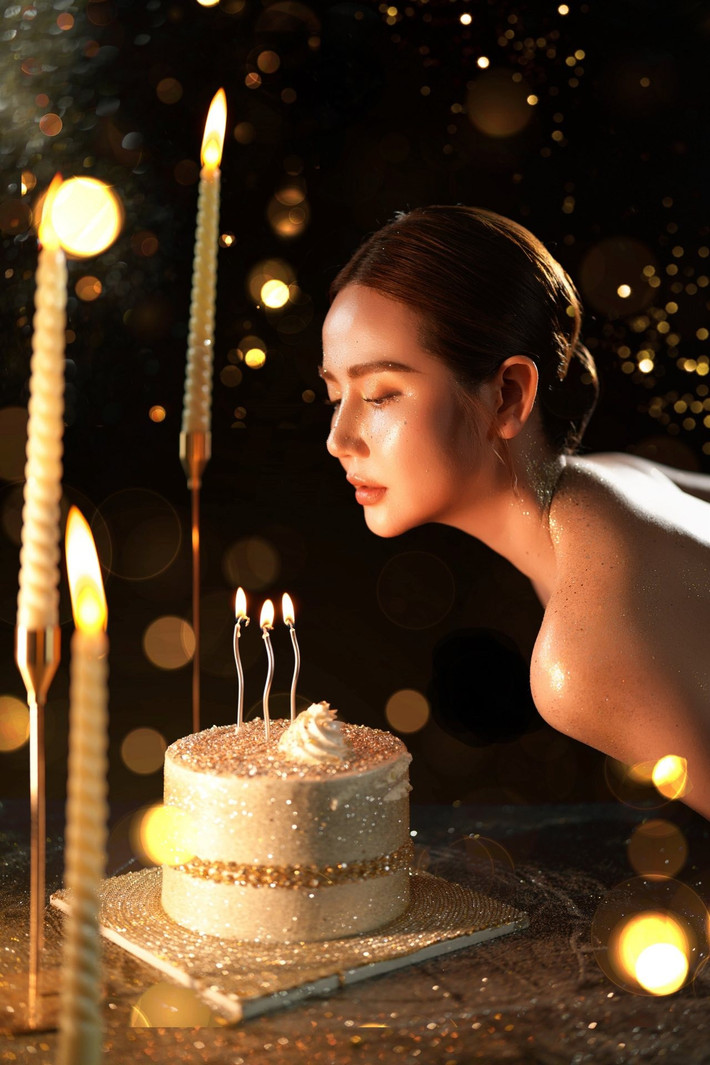 Cô nàng diện chiếc váy quây màu đen quyến rũ, khoe đôi vai trần được nhấn bằng nhũ vàng tôn lên vẻ huyền bí và lấp lánh.