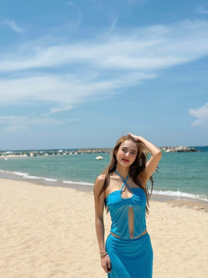 Xuất hiện trong ảnh, Khánh Chi diện chiếc váy xanh khá mát mắt cùng những đường cắt xẻ khoe vòng 1 lấp ló.
