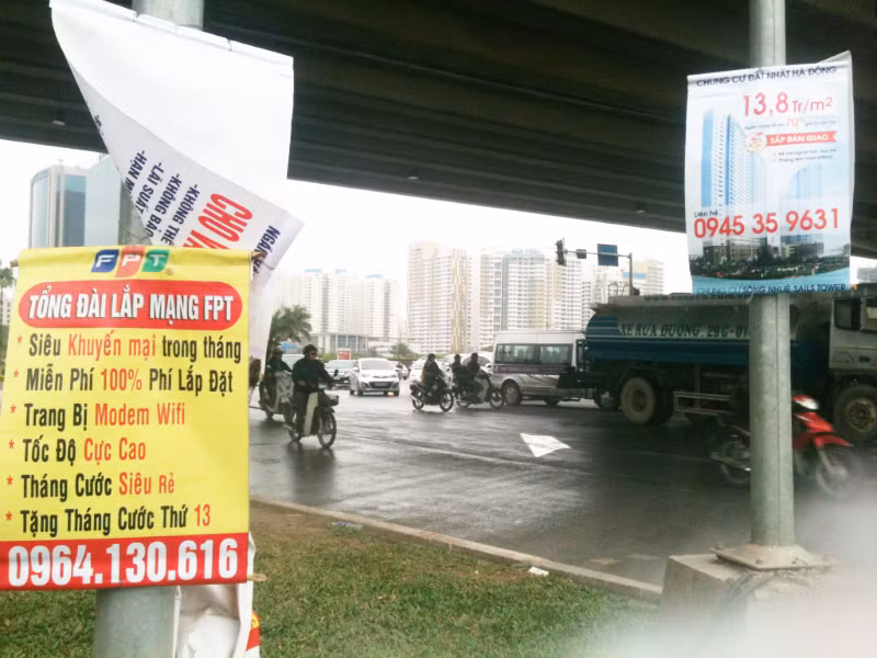 Nhếch nhác biển quảng cáo “đu” cột điện, đèn đường