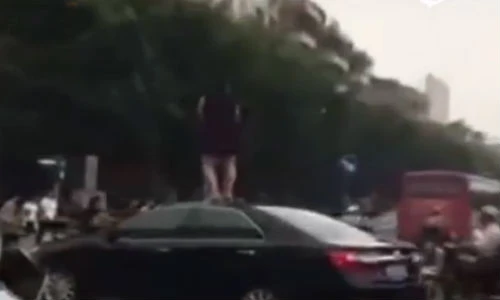 Phụ nữ vượt đèn đỏ, nhảy lên nóc ô tô nhảy múa