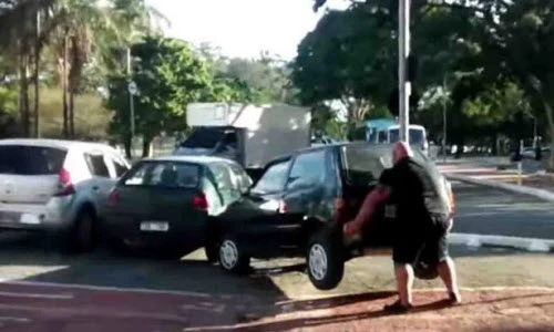 Người đi xe đạp tay không nhấc bổng ô tô chắn đường