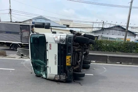 TPHCM: Xe tải va dải phân cách rồi lật, hai người đi xe máy thoát nạn