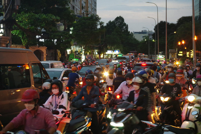 Người đi bộ kẹt giữa dòng xe dưới các cao ốc ở TP HCM - Hình 2 Nguoi di bo ket giua dong xe duoi cac cao oc o TP HCM-Hinh-2