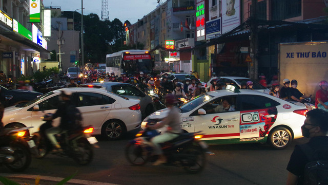 Người đi bộ kẹt giữa dòng xe dưới các cao ốc ở TP HCM - Hình 4 Nguoi di bo ket giua dong xe duoi cac cao oc o TP HCM-Hinh-4