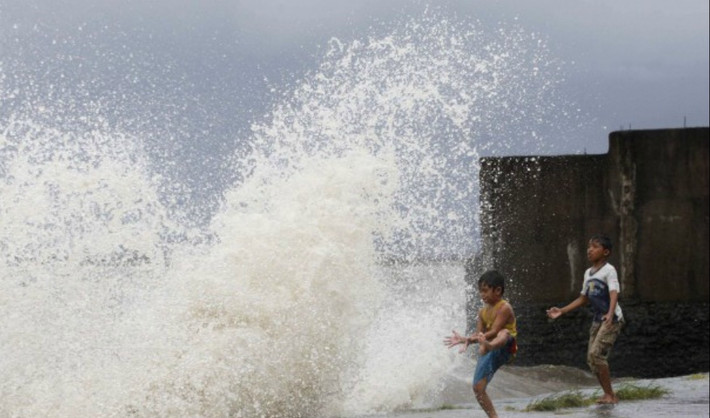 Hai bé trai ở thị trấn ven biển Bayog, phía nam Manila, vô tư đùa với sóng dữ, mà không biết rằng rất nguy hiểm tới tính mạng.