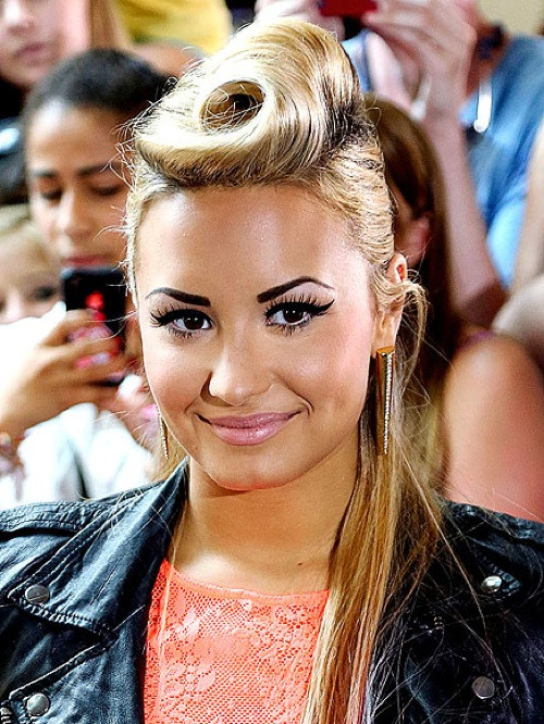 Demi Lovato chọn tóc búi cuốn retro lạ lẫm. Để tạo được kiểu tóc này, các chuyên gia làm đẹp cần tới máy làm xoăn tay, lược chải chuyên dụng, ghim kẹp tóc và thật nhiều gôm giữ nếp.
