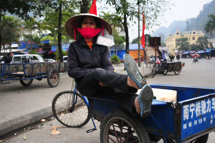 Một người chở hàng thuê đang chờ đợi những mẻ hàng cuối cùng để kiếm thêm những đồng bạc nhỏ nhoi về quê đoàn tụ với gia đình.