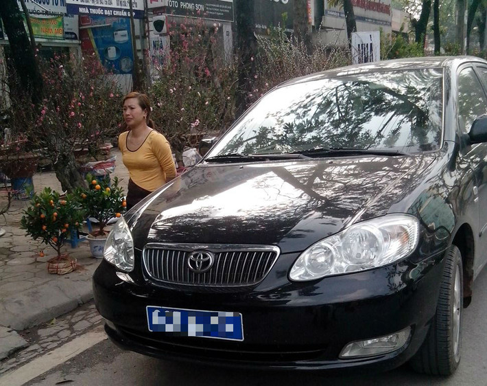 Không chỉ đưa xe công đi nhậu nhẹt, cafe, karaoke, một chiếc xe biển xanh khác đang tranh thủ mua đào, quất trên đường Hoàng Quốc Việt.