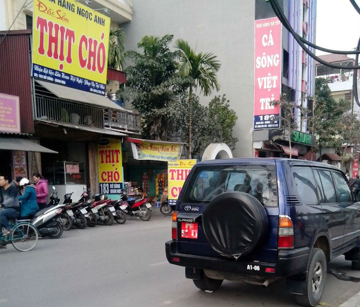 Một chiếc xe biển đỏ thuộc biên chế trong quân đội đang đợi "sếp" trước một quán thịt chó trên đường Bờ sông Quan Hoa (Cầu giấy).