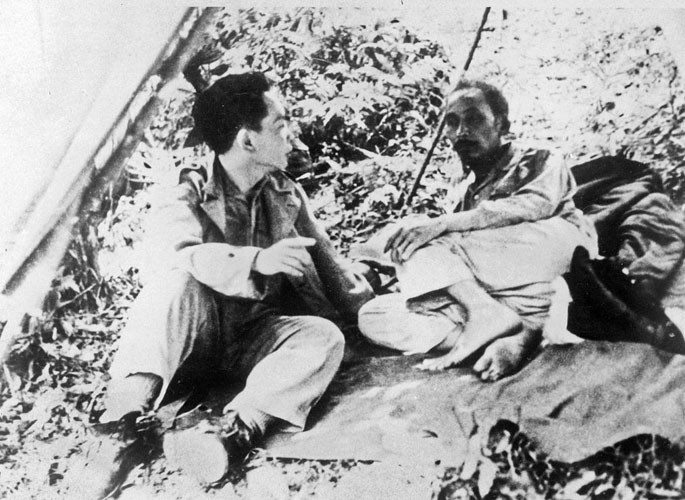 Chủ tịch Hồ Chí Minh (phải) và Đại tướng Võ Nguyên Giáp (trái) ngồi nghỉ tại một địa điểm không rõ trong Chiến dịch Biên giới. Ảnh AP.
