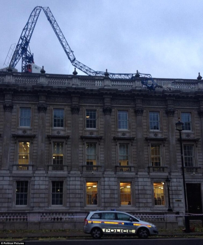 ... các tòa nhà bị bão tàn phá, mất điện trên diện rộng. Trong ảnh, một cần trục ở Downing Street đổ sập lên mái của Văn phòng Nội các Anh.