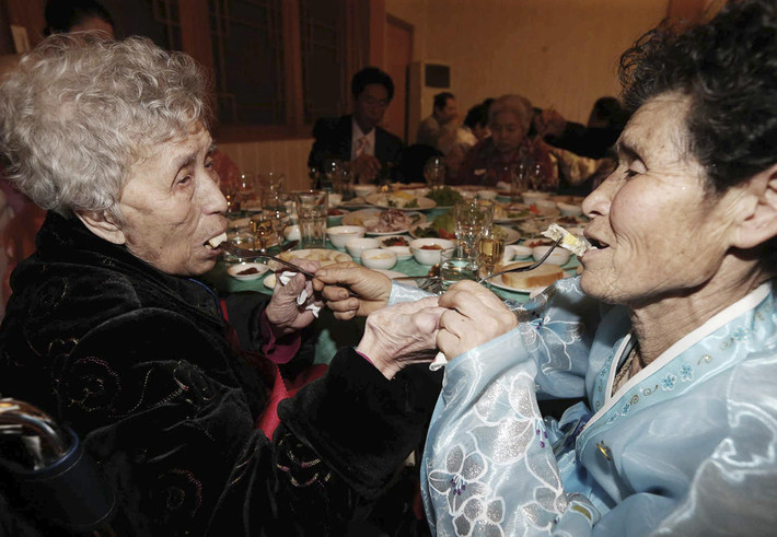 Trong ảnh, là cảnh mẹ con cụ bà Lee Young Shil (Hàn Quốc), 87 tuổi (trái) và người con gái Myung- sook, 66 tuổi đang sống ở Triều Tiên đút cho nhau ăn.