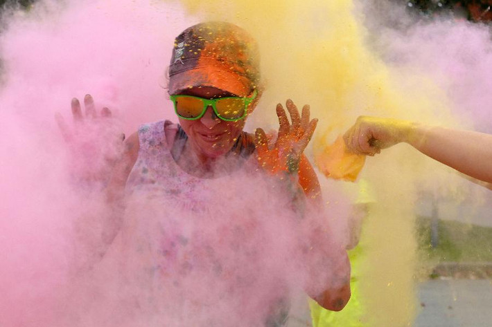 Cô gái trẻ tỏ ra phấn khích khi hứng trong cơn mưa bột màu trong cuộc thi chạy Colour Me Rad 5K 2013.