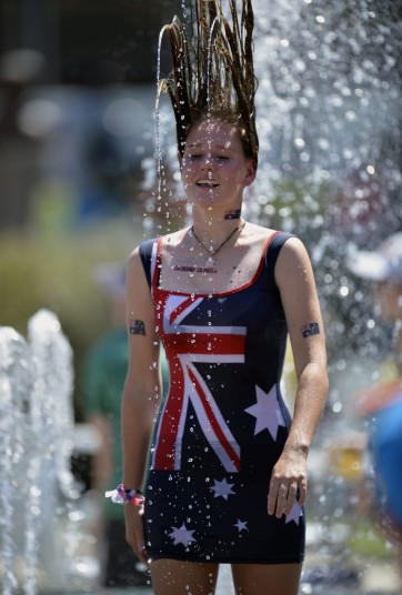 Đợt nắng nóng kinh hoàng đang hoành hành ở Australia dẫn đến cháy rừng và đe dọa tính mạng con người (dễ xảy ra tình trạng say nắng, mất nước..) Trong ảnh, một cô gái tắm mình dưới đài phun nước để hạ nhiệt.