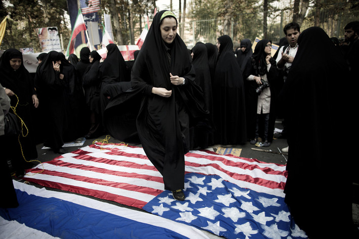 Một phụ nữ Iran dẫm lên lá cờ Mỹ bên ngoài trụ sở cũ của Đại sứ quán nước này tại Tehran trong cuộc biểu tình vào ngày 4/11.