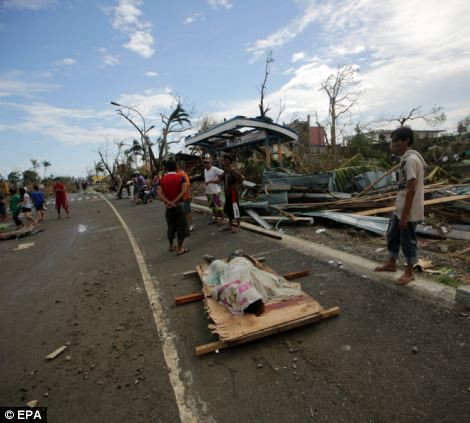 Thi thể của một nạn nhân siêu bão Haiyan nằm trên cáng đặt trên con đường đường nhựa ở Tacloban.