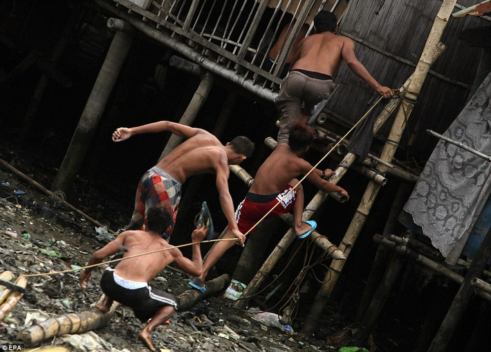Cư dân thành phố Las Pinas, phía nam Manila vội vã leo lên một khu tránh bão được xây cao hơn so với mặt đất.