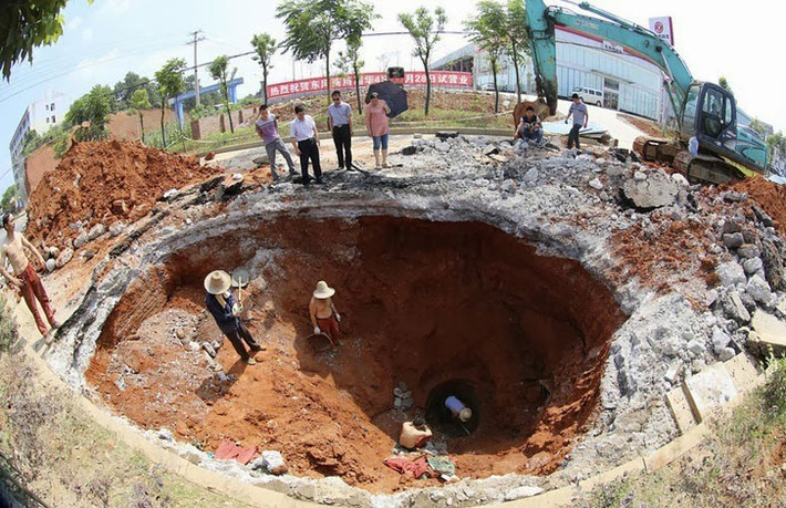 Đội cứu hộ miệt mài giải cứu nạn nhân rơi xuống hố tử thần ở Loudi, Hồ Nam ngày 18/6/2013. Hố tử thần này xuất hiện sau khi chiếc xe tải đi qua. Một chiếc xe mô tô đi phía sau bị rơi xuống hố và lái xe bị thương.