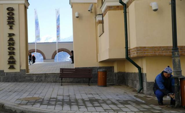 Một công nhân đang sửa chữa chân cột đèn tại làng Esto Sadok thuộc khu nghỉ mát núi cao Rosa Khutor gần Sochi, một địa điểm diễn ra các môn thi đấu Thế vận hội.