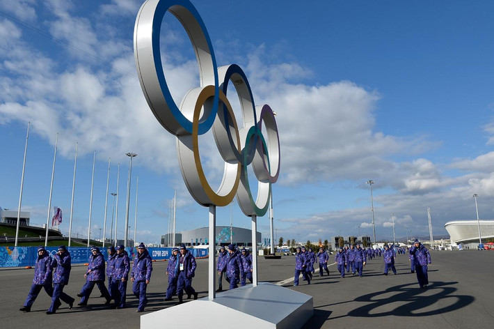 Một đội nhân viên an ninh đi bộ qua một sân vận động trong công viên Olympic.