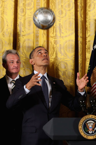 Tổng thống Mỹ Barack Obama tung một quả bóng trong khi chủ trì buổi lễ tôn vinh các cầu thủ và huấn luyện viên tham gia giải khúc côn cầu quốc gia tại Phòng Đông Nhà Trắng ngày 26/3/2013.