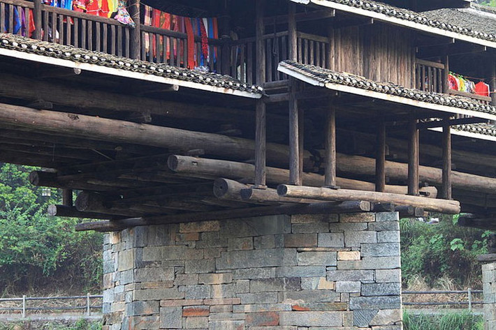 Một cây cầu "Phong vũ" thường được xây dựng bằng gỗ là chính với cấu trúc bao gồm thân cầu, một tòa tháp và căn đình được chạm khắc rồng phượng tinh tế.