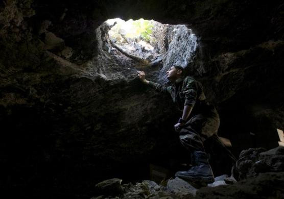 Phiến quân Syria ở trong một hang động ở làng Maaret al-Naaman, tỉnh Idlib quan sát tình hình bên ngoài thông qua một cái hố ngày 17/10.