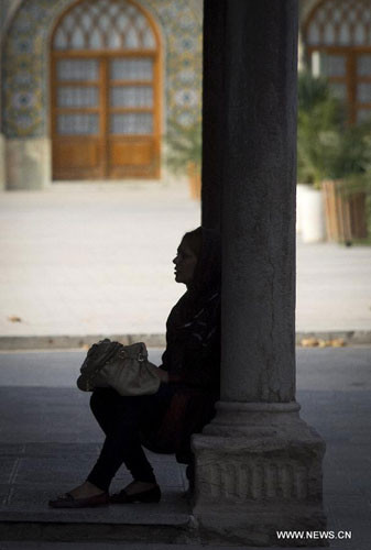 Một phụ nữ trẻ ngồi bên chiếc cột trong cung điện Golestan.