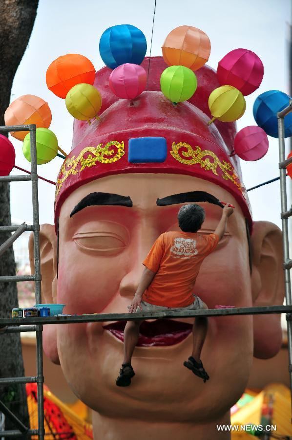 Trong khi đó, ở Singapore, công việc chuẩn bị đón Tết Nguyên đán cũng bắt đầu rục rịch. Trong ảnh, một thợ thủ công đang vẽ lông mày cho chiếc đèn lồng hình Thần tài khổng lồ cho dịp tết. Ảnh chụp ngày 10/1.