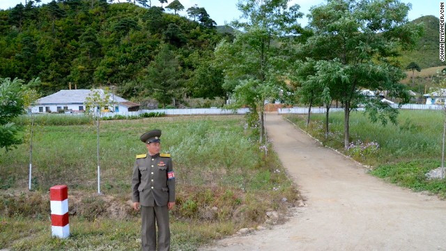 Một nhân viên an ninh Triều Tiên được giao nhiệm vụ giám sát các tay đua xe đạp gần một ngôi làng nhỏ.