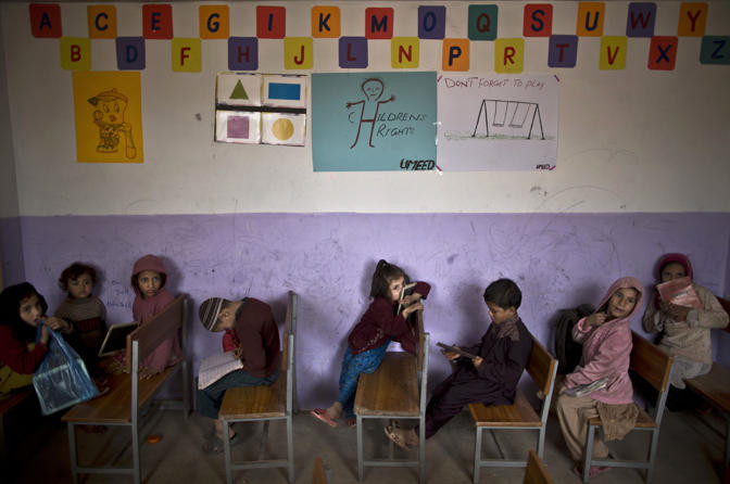 Con em của dân tị nạn người Afghanistan ngồi trong lớp học ở bên ngoài ngoại ô Islamabad ngày 5/11. Pakistan là nhà của 1,6 triệu người tị nạn Afghanistan, do đó người tị nạn trong thành phần dân số nước này có tỷ lệ lớn nhất thế giới. Cuộc sống của các gia đình tị nạn ở Pakistan rất bấp bênh, khốn khó.