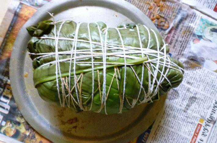 Dùng lá sen rửa sạch bọc kín gà. Tuyệt đối không để hở bất kỳ phần nào rồi dùng dây quấn lại.