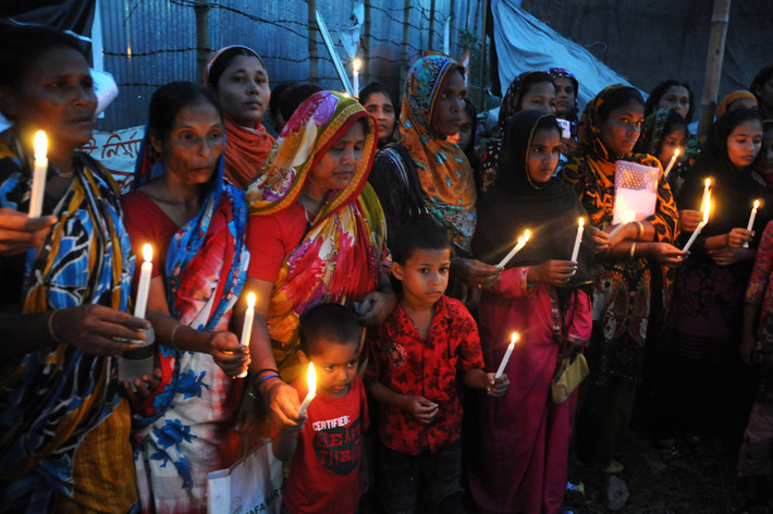 Công nhân dệt Bangladesh tưởng nhớ người thân thiệt mạng trong thảm họa sập tòa nhà Rana Plaza ở ngoại ô Dhaka, cướp đi mạng sống của khoảng 1.135 người ngày 24/10 tại một đài tưởng niệm.