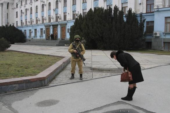 Một phụ nữ ở Simferopol cúi đầu thể hiện sự biết ơn và sự mến mộ đối với thành viên Lực lượng an ninh đang giúp giữ gìn trật tự trong khu vực.