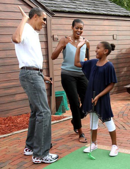 Ông bố Obama hướng dẫn cô con gái Sasha chơi golf.