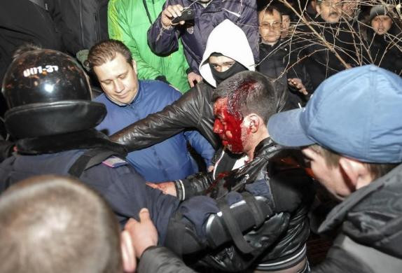 Theo Reuters, hàng trăm người biểu tình thuộc hai phe, một ủng hộ Moscow và một ủng hộ chính phủ mới ở Kiev đã lao vào ẩu đả nhưng không rõ nạn nhân thiệt mạng thuộc phe nào. Trong ảnh, cảnh sát Donetsk hộ tống một người bị thương nặng, máu chảy đầy mặt ra khỏi đám đông hỗn loạn.