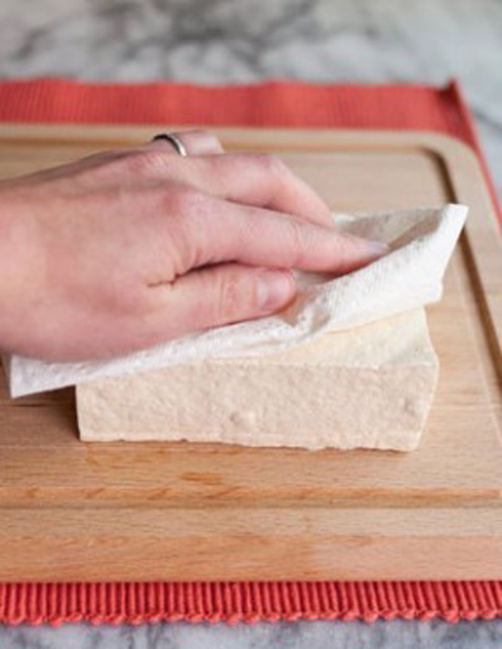 Trường hợp đậu mua về quá mềm hoặc sũng nước, chị em có thể dùng chiếc khăn mỏng quấn quanh đậu rồi dùng vật nặng như viên gạch nhỏ hoặc vài cuốn sách để ép chừng 5 – 10 phút. Bằng cách này, đậu sẽ thơm ngon hơn; hạn chế lượng mỡ trong chảo bắn ra ngoài khi rán.