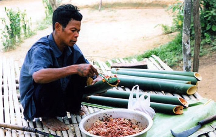 Sau công đoạn tẩm ướp công phu, thịt trâu được cuộn lá nồm rồi cho vào ống tre tươi.