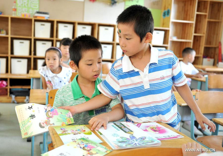 Cặp song sinh Xu Chenxi và Xu Chenyang học cùng lớp, ngồi cùng bàn sắp xếp sách giáo khoa của nhau trong ngày khai giảng.