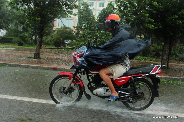 Một người dân ở thành phố Tam Á phi xe máy trong cơn mưa lớn.