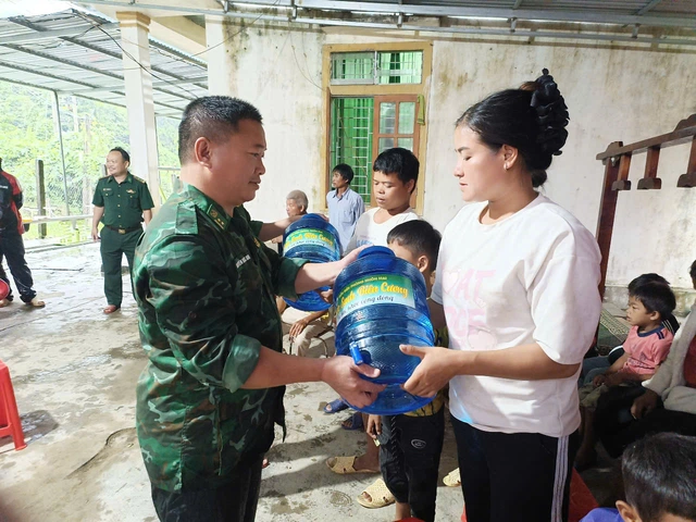 Lực lượng chức năng hỗ trợ nước uống, lương thực cho các hộ dân bị di dời. hhh.png