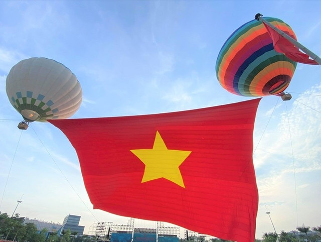 Lá đại kỳ đỏ thắm, với diện tích 2.025m², được kéo lên giữa nền trời trong xanh, trong tiếng nhạc hào hùng của bài Tiến quân ca, đã trở thành khoảnh khắc đặc biệt, lắng đọng trong tâm trí hàng nghìn người có mặt tại quảng trường Hồ Chí Minh kk.jpg