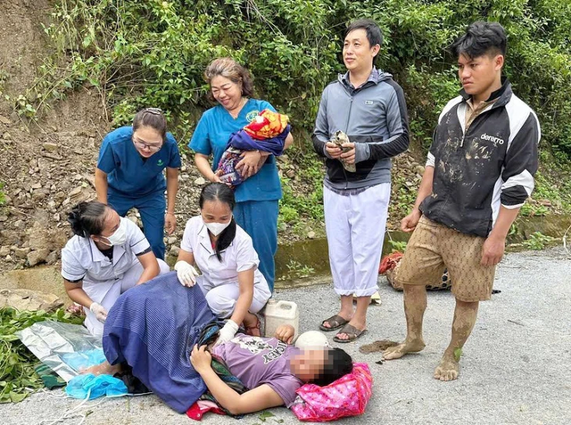 Các y bác sĩ đỡ đẻ cho sản phụ giữa đường núi. anh-bai.png