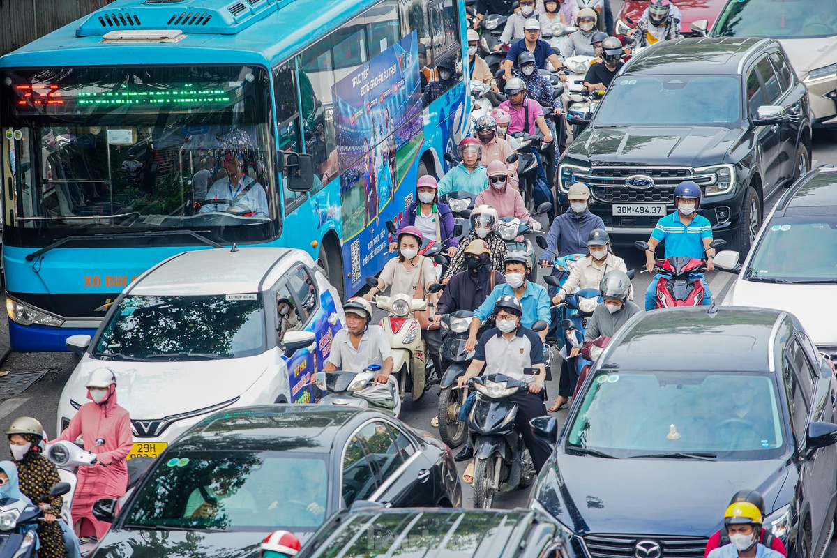 Nhiều phương tiện ô tô đi sát vỉa hè, làn ngoài cùng bên phải khiến hàng dài xe máy bị kẹt phía sau.