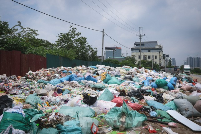 Bãi rác lớn chất đầy bánh kẹo và rác thải sinh hoạt nằm ngay đường lớn dẫn vào làng La Phù.
